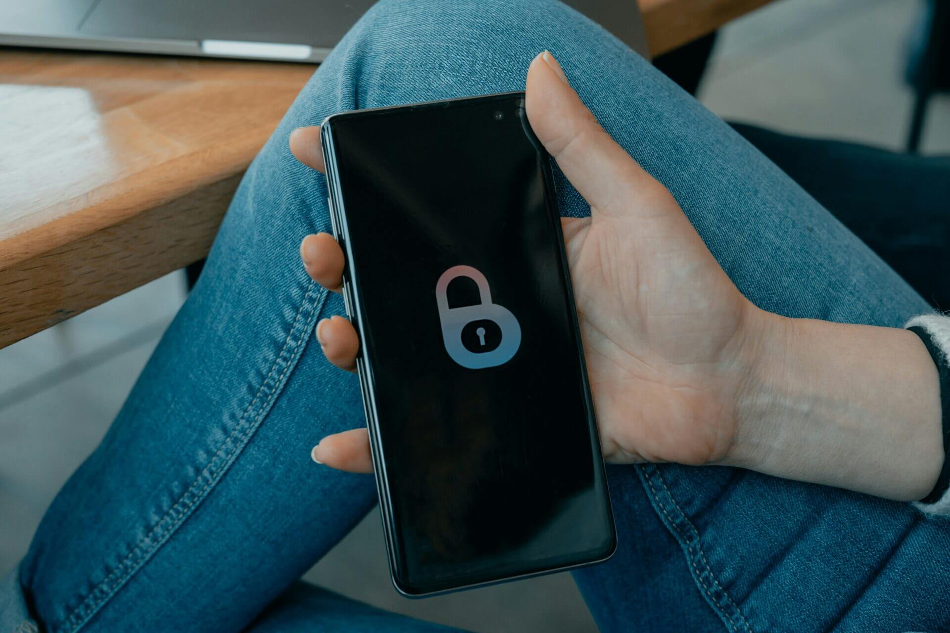 A person holding a phone, with a lock screen on it