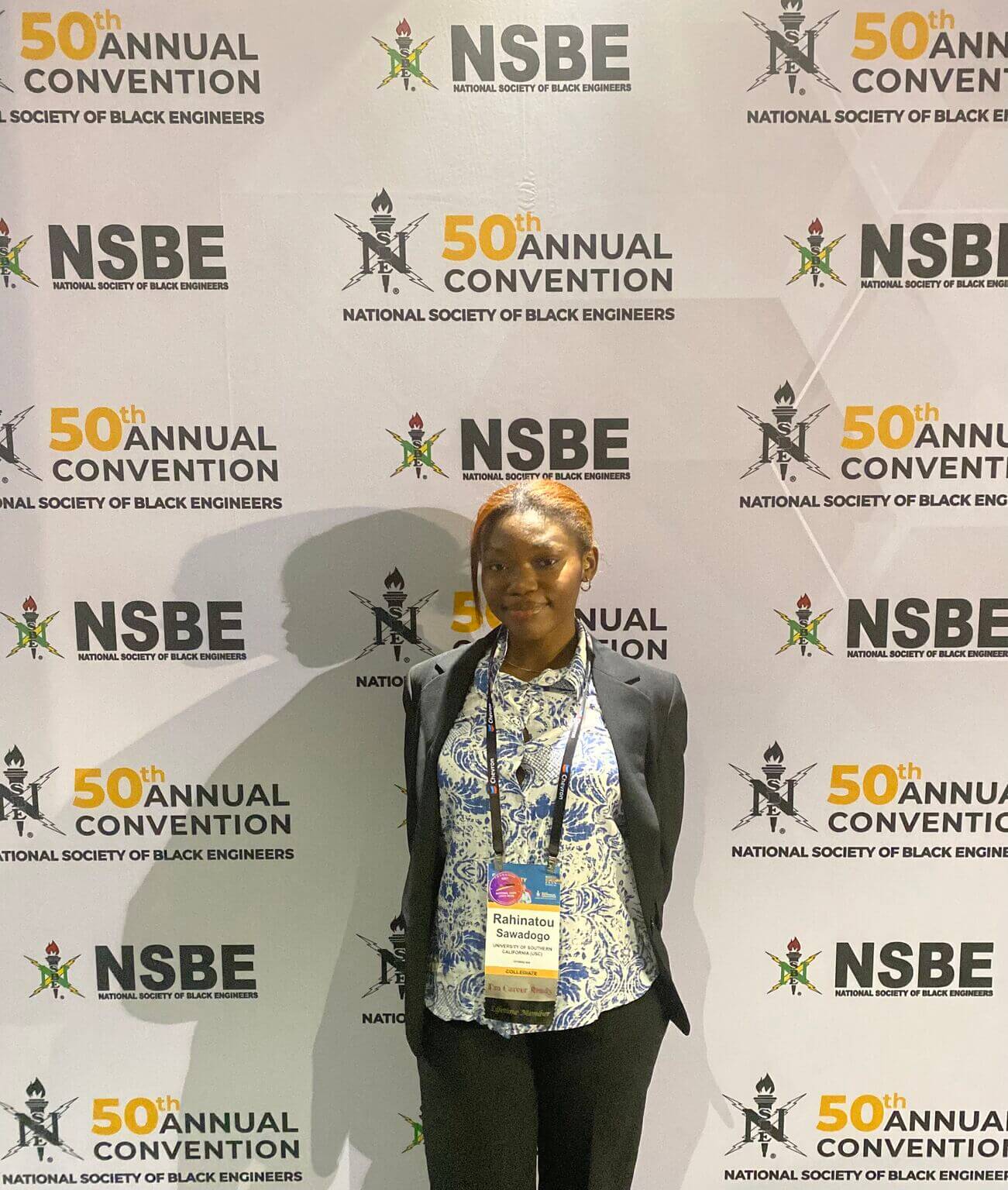 Student Rahinatou Sawadogo in front of a NSBE backdrop